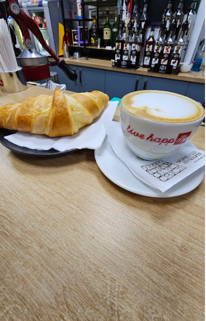 Croissant proaspăt și cappuccino illy pe tejghea